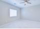 This bedroom features a ceiling fan, natural light, and sleek tile floors at 12940 W Tara Ln, Surprise, AZ 85374