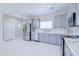 Modern kitchen featuring stainless steel appliances, grey cabinets, quartz countertops, and a stylish backsplash at 12940 W Tara Ln, Surprise, AZ 85374