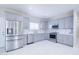 Well-lit kitchen showcasing stainless steel appliances, grey cabinets, quartz countertops, and ample counter space at 12940 W Tara Ln, Surprise, AZ 85374