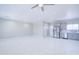 Open-concept living room showcasing tiled floors, neutral paint, a ceiling fan, and kitchen access at 12940 W Tara Ln, Surprise, AZ 85374