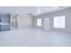 Bright living room with tiled floors, large windows, and a view of the entryway and kitchen at 12940 W Tara Ln, Surprise, AZ 85374
