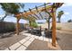 This outdoor patio area features a pergola, desert landscaping, and seating area at 13160 W Windsor Ave, Goodyear, AZ 85395