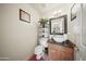 This charming powder room features a vessel sink and storage shelving at 13160 W Windsor Ave, Goodyear, AZ 85395
