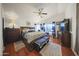 This primary bedroom features a ceiling fan, wood floors, and stylish decor at 13160 W Windsor Ave, Goodyear, AZ 85395