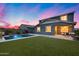 Private backyard with a swimming pool, green grass, and a covered patio for outdoor entertaining at 13237 W Redstone Dr, Peoria, AZ 85383