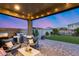 An outdoor kitchen featuring a grill, a manicured lawn and a firepit are the highlights of this backyard at 13237 W Redstone Dr, Peoria, AZ 85383