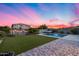 This backyard has a lush lawn, a swimming pool, and colorful flowers along the perimeter walls at 13237 W Redstone Dr, Peoria, AZ 85383