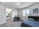 This bedroom features neutral walls, a large window, plush carpeting, and an adjoining bathroom with dual sinks at 13237 W Redstone Dr, Peoria, AZ 85383