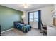 This bedroom has a large window and a workstation; the walls are painted a modern green at 13237 W Redstone Dr, Peoria, AZ 85383