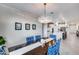 Elegant dining room features a crystal chandelier, bold blue seating, and seamless transition to kitchen at 13237 W Redstone Dr, Peoria, AZ 85383