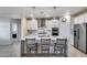 Stunning kitchen with island seating, stainless appliances, pendant lighting, and access to other rooms at 13237 W Redstone Dr, Peoria, AZ 85383