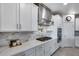 Gourmet kitchen showcasing a gas range, marble backsplash, stainless steel hood, and modern appliances at 13237 W Redstone Dr, Peoria, AZ 85383