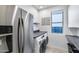 Functional laundry room with modern washer, dryer, stainless steel refrigerator, and plenty of storage space at 13237 W Redstone Dr, Peoria, AZ 85383