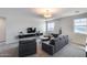 Bright living room features gray seating, a modern floating console, and natural light from a window at 13237 W Redstone Dr, Peoria, AZ 85383