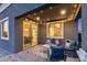 Covered patio has stylish outdoor seating, patterned rugs, and leads to the house with sliding glass doors at 13237 W Redstone Dr, Peoria, AZ 85383