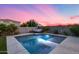 Sparkling pool and spa area with desert landscaping against a colorful sunset backdrop at 13237 W Redstone Dr, Peoria, AZ 85383