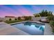 Backyard featuring a pool, spa, artificial turf, and string lights creating a relaxing ambiance at 13237 W Redstone Dr, Peoria, AZ 85383