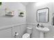 Stylish powder room featuring a pedestal sink, modern fixtures, and wainscoting for a chic look at 13237 W Redstone Dr, Peoria, AZ 85383