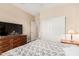 Comfortable bedroom with a large TV, ceiling fan, and sliding door closet at 15452 W Skyview Way, Surprise, AZ 85374