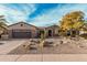 Charming home features a desert landscape, stone accents, and a brown two-car garage at 15452 W Skyview Way, Surprise, AZ 85374