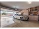 Clean, well-lit garage featuring a car and storage cabinets at 15452 W Skyview Way, Surprise, AZ 85374