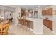 Modern kitchen featuring a breakfast bar, wood cabinets, stainless steel appliances, and tile flooring at 15452 W Skyview Way, Surprise, AZ 85374