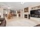 Open-concept living area with cozy fireplace, adjoining the kitchen, dining area, and featuring neutral tile flooring at 15452 W Skyview Way, Surprise, AZ 85374