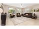 Inviting living room featuring a comfortable brown leather sofa and abundant natural light from the large windows at 15452 W Skyview Way, Surprise, AZ 85374