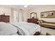 Comfortable main bedroom featuring an ensuite bath, neutral carpeting, dresser, and warm paint at 15452 W Skyview Way, Surprise, AZ 85374