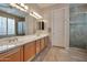 Bathroom with double sink, large mirror, and tiled shower with glass door at 15634 S 31St St, Phoenix, AZ 85048