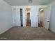 Well-lit bedroom with neutral walls, soft carpeting, a closet, and doorways offering seamless transition to other rooms at 15794 W Cheryl Dr, Waddell, AZ 85355