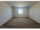 Large bedroom with carpet flooring and a bright window providing natural light at 15794 W Cheryl Dr, Waddell, AZ 85355