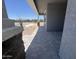 A covered porch entrance showcasing stone pillars and a paved walkway, offering an inviting outdoor transition space at 15794 W Cheryl Dr, Waddell, AZ 85355