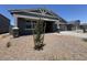 View of a charming gray single-story home with a covered porch and gravel landscaping, complemented by a blue sky at 15794 W Cheryl Dr, Waddell, AZ 85355