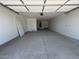A spacious, clean garage featuring white walls, a concrete floor, and a door leading to the interior of the home at 15794 W Cheryl Dr, Waddell, AZ 85355