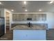Modern kitchen showcasing a central island, granite countertops, and stainless steel appliances at 15794 W Cheryl Dr, Waddell, AZ 85355