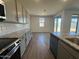 Stylish kitchen featuring sleek cabinets, granite countertops, stainless appliances, and backyard access at 15794 W Cheryl Dr, Waddell, AZ 85355