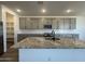 Modern kitchen featuring gray cabinetry, granite countertops, stainless steel appliances, and a stylish central island at 15794 W Cheryl Dr, Waddell, AZ 85355