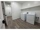 Well-equipped laundry room with modern washer, dryer, and convenient built-in shelving at 15794 W Cheryl Dr, Waddell, AZ 85355