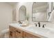 Bathroom featuring a double sink vanity, arched mirrors, and modern black fixtures at 1609 W Yukon Dr, Phoenix, AZ 85027