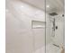 Modern bathroom featuring a frameless glass shower with black fixtures and white marble-style tiling at 1609 W Yukon Dr, Phoenix, AZ 85027
