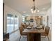 Open concept dining room with a modern chandelier, leading to a spacious kitchen and outdoor patio at 1609 W Yukon Dr, Phoenix, AZ 85027