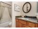 Bathroom with a dark stone vanity, round mirror, framed art and a bathtub with shower at 16538 E Westwind Ct # 51, Fountain Hills, AZ 85268