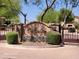Welcoming gated community entrance with manicured landscaping and an attractive sign reading 