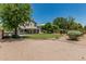 A sprawling backyard with covered patio, lush lawn, mature landscaping, and additional patio area at 1705 W Lark Dr, Chandler, AZ 85286
