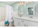 Well-lit bathroom featuring dual sinks, white countertops, and a shower-tub combination with a curtain at 1705 W Lark Dr, Chandler, AZ 85286