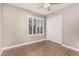 Cozy bedroom featuring wood-look tile flooring, plantation shutters, and a ceiling fan for added comfort at 1705 W Lark Dr, Chandler, AZ 85286