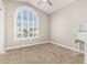 Bedroom with a large window, arched window, a desk, and neutral carpet at 1705 W Lark Dr, Chandler, AZ 85286