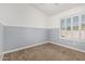 Bright bedroom with neutral carpet, wainscotting, and a window with white shutters at 1705 W Lark Dr, Chandler, AZ 85286