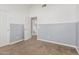 A carpeted bedroom features neutral colors, wainscotting, and an open door leading to the bathroom at 1705 W Lark Dr, Chandler, AZ 85286